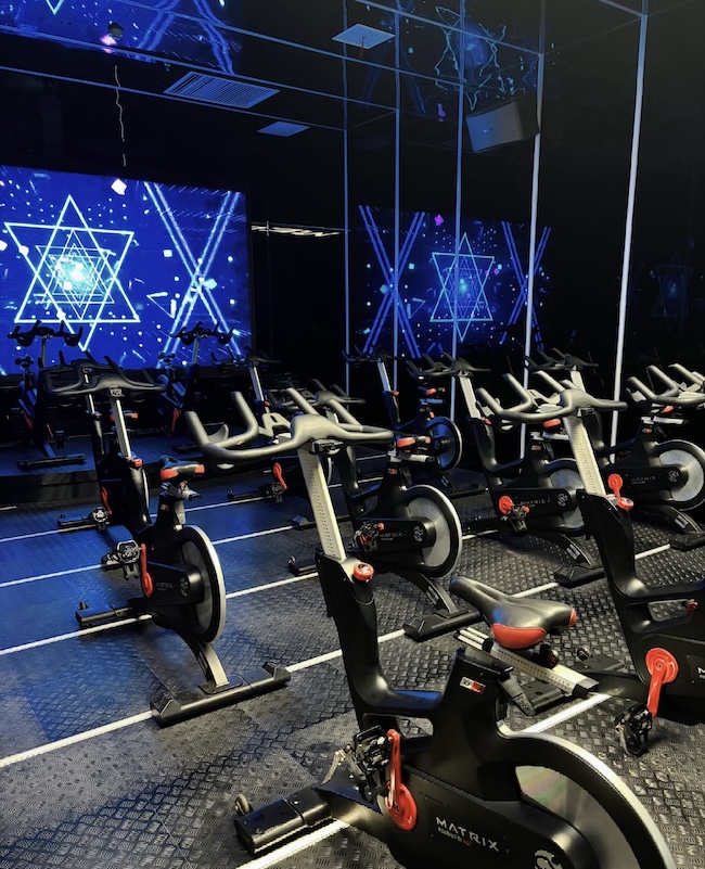NOVRAXA gym equipment procurement guide showing a treadmill, chest press, and functional trainer with English and Arabic labels. NOVRAXA gym equipment procurement guide showing a treadmill, chest press, and functional trainer with English and Arabic labels.